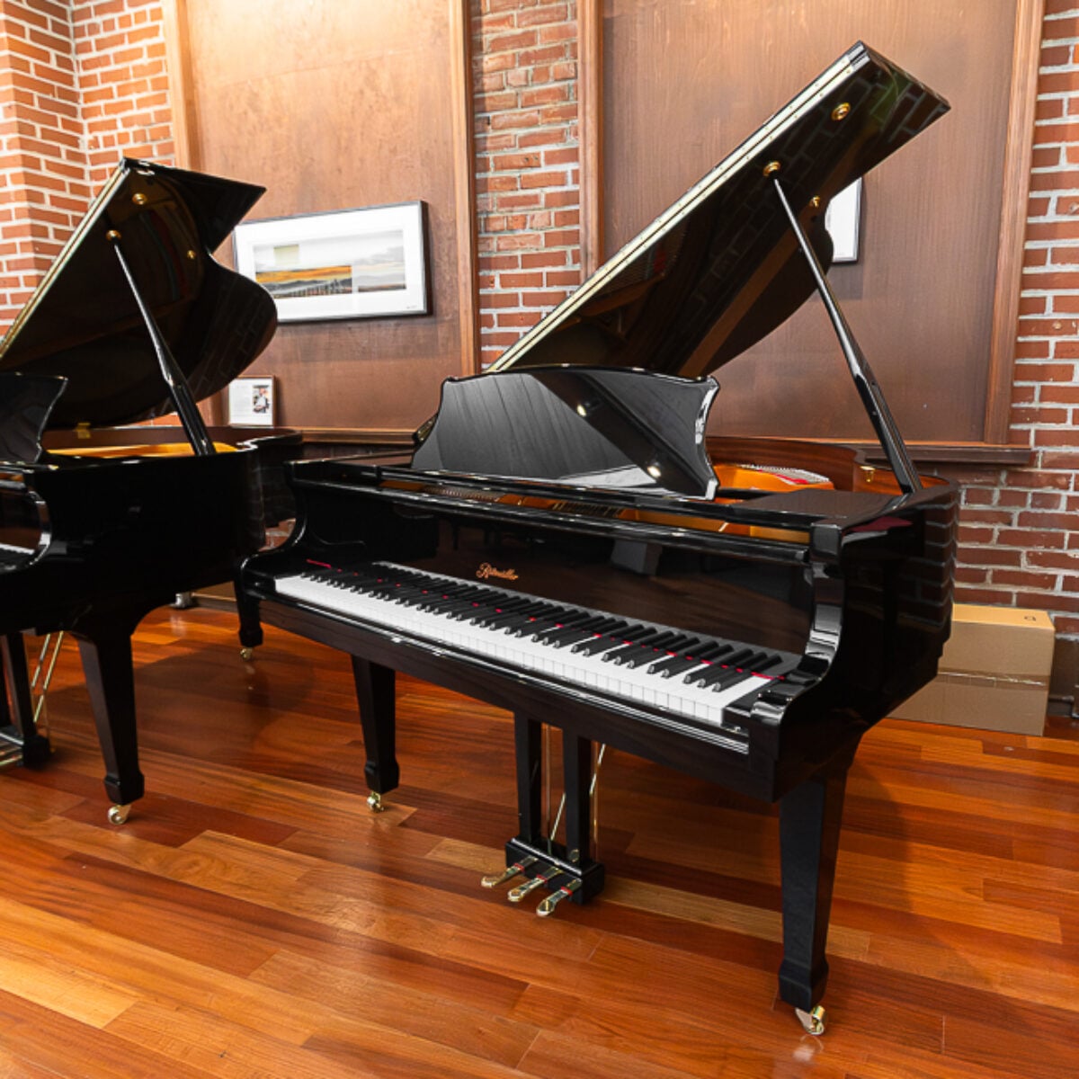 Black grand piano with polished ebony finish at Classic Pianos Portland showroom, showcasing fine craftsmanship.