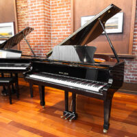 Pearl River grand piano with polished ebony finish displayed in Classic Pianos Portland showroom.