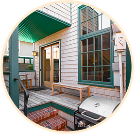 Outdoor patio area with wood bench and BBQ grill, perfect for a relaxing break at Classic Pianos Portland showroom.