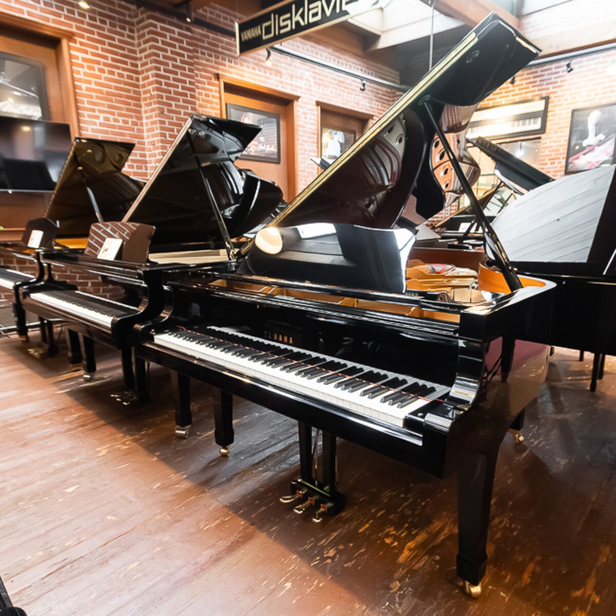 ```markdown
Yamaha Disklavier grand piano in glossy black finish displayed at Classic Pianos Portland showroom.
```