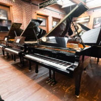 ```markdown
Yamaha Disklavier grand piano in glossy black finish displayed at Classic Pianos Portland showroom.
```