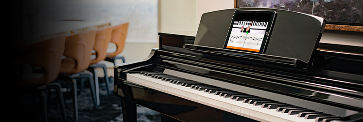 Yamaha digital piano in polished ebony finish with integrated smart technology display for interactive learning.