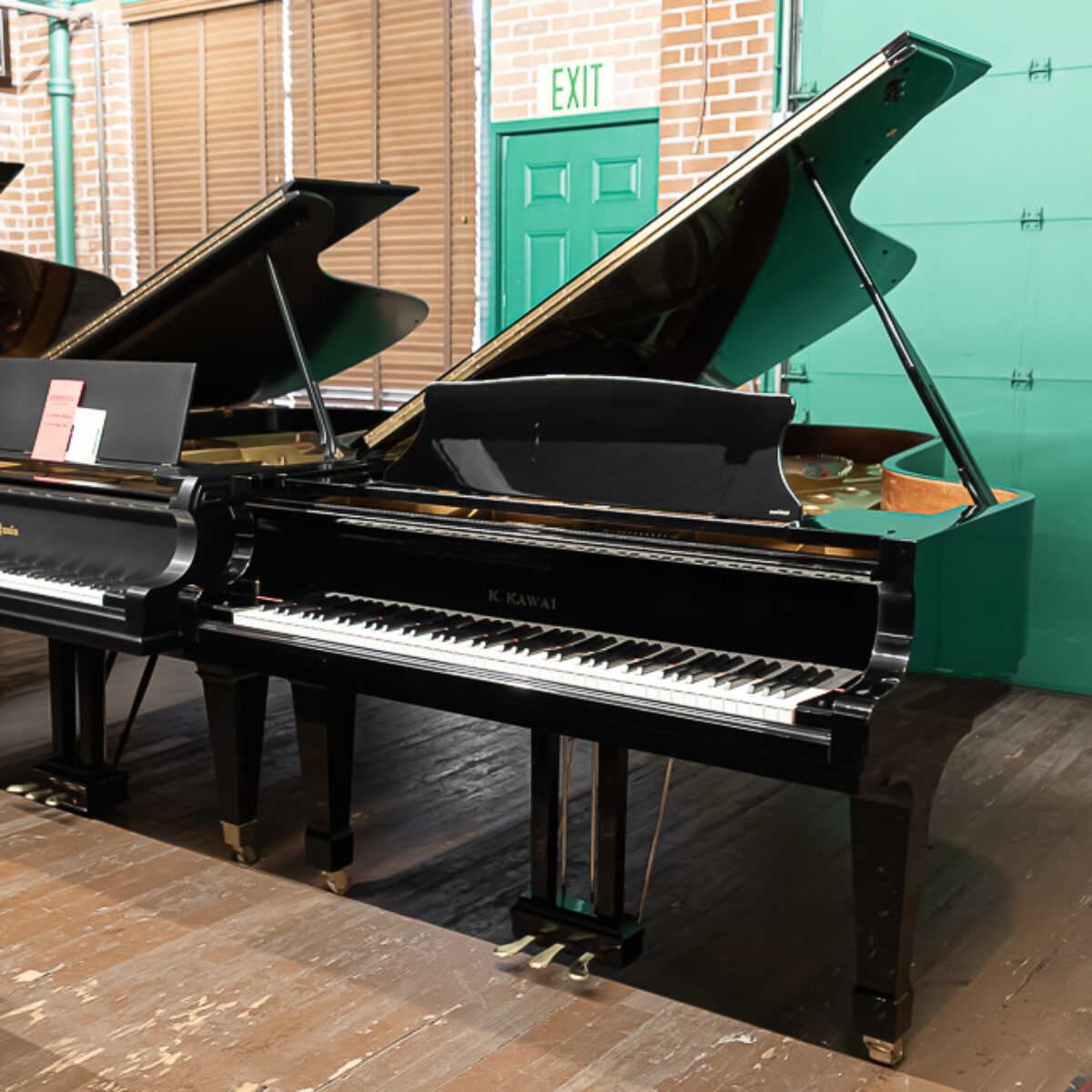 Kawai grand piano in showroom at Classic Pianos Portland, showcasing polished ebony finish and precise craftsmanship.