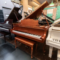 Yamaha grand piano with polished mahogany finish in showroom. Premium sound, quality materials.