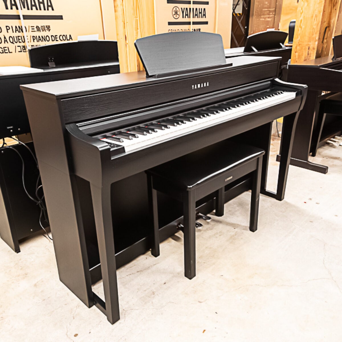 Yamaha digital piano in sleek black finish, featuring weighted keys and matching bench for a premium playing experience.