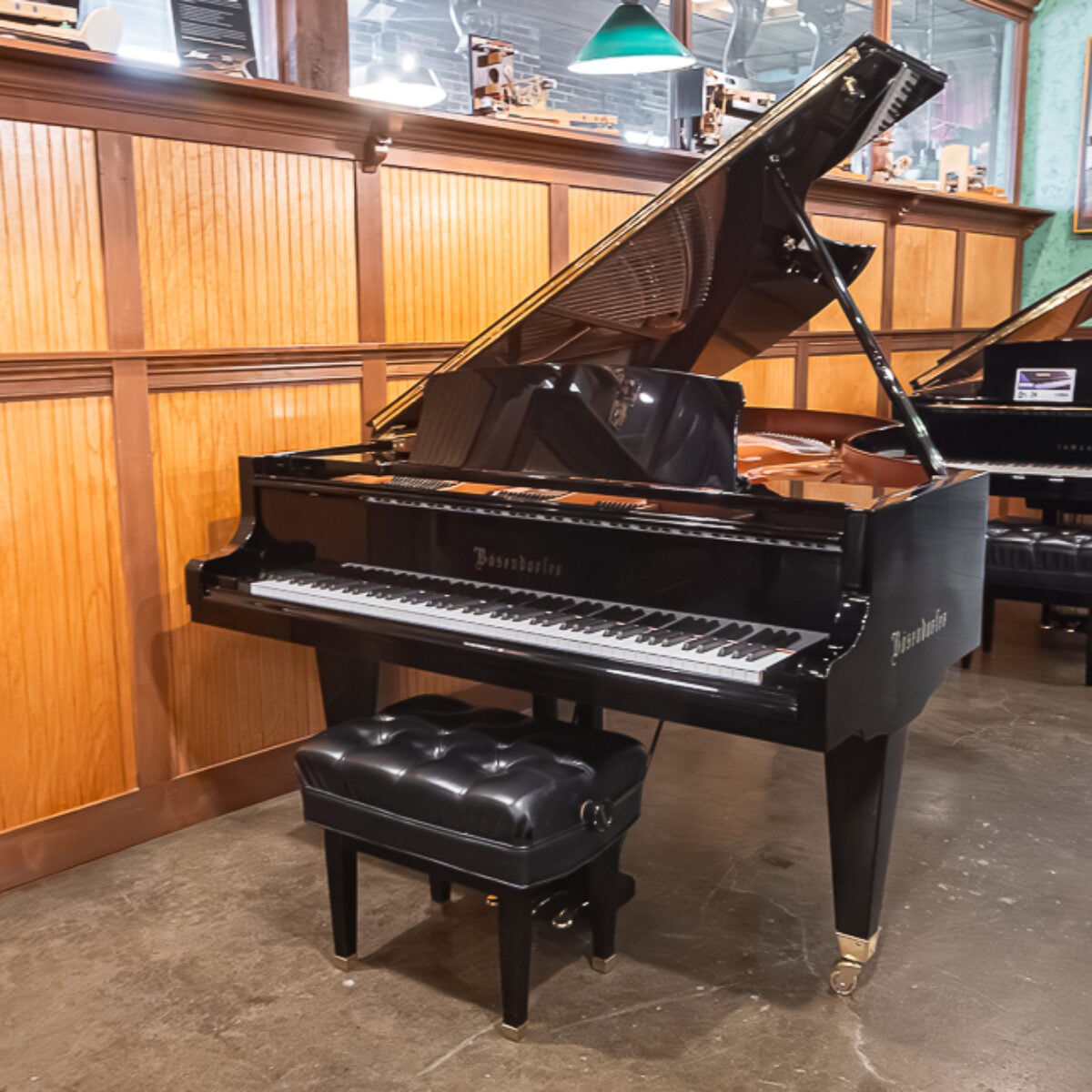 Elegant Boston upright piano with polished ebony finish and black tufted bench, available at Classic Pianos Portland.