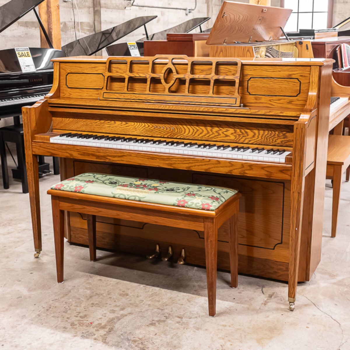 Oak console piano with an elegant design, featuring a matching bench and classic white keys, perfect for home musicians.