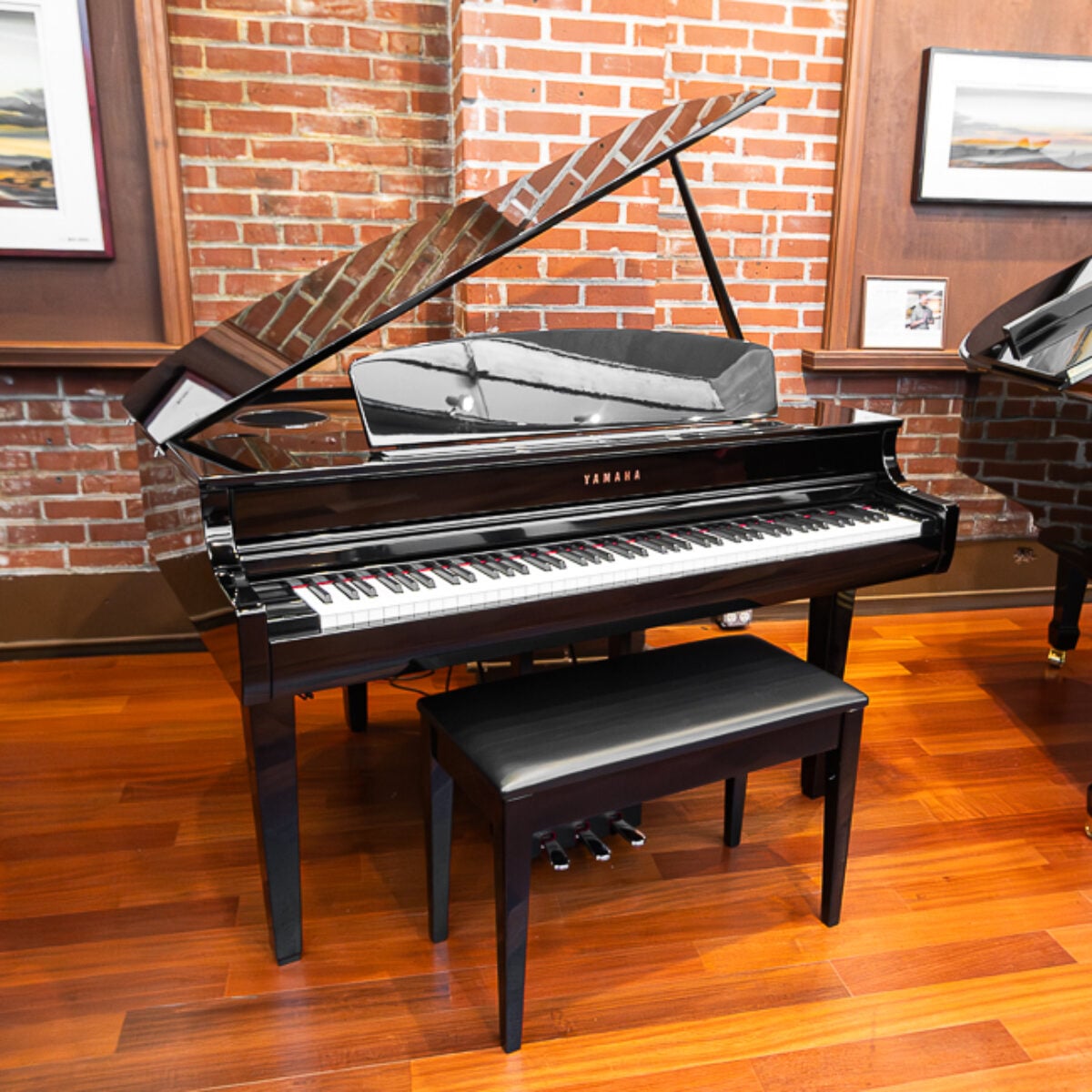 Yamaha grand piano with polished black finish and matching bench, showcasing craftsmanship and acoustic excellence.