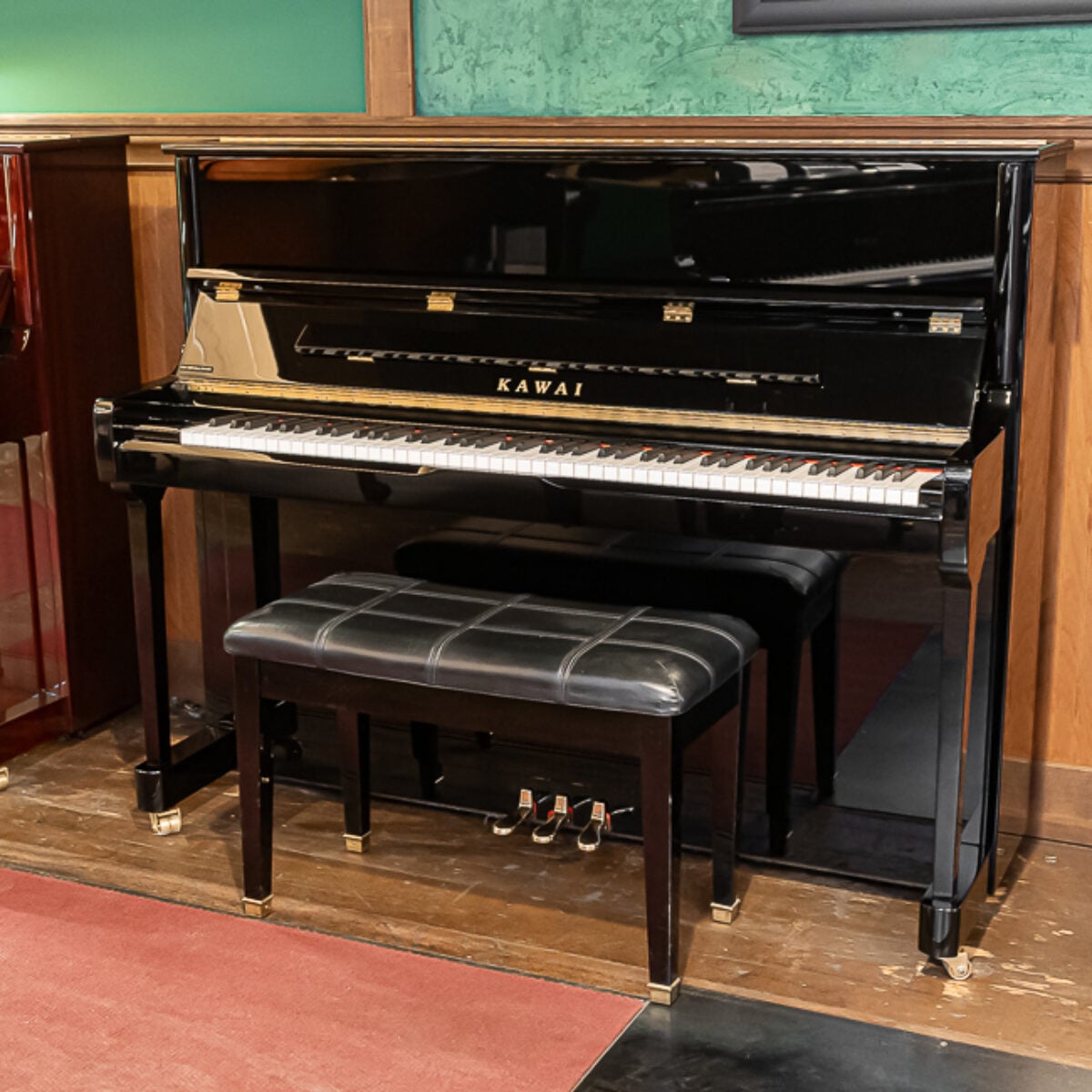 Kawai upright piano with polished ebony finish and matching bench, showcasing exquisite craftsmanship and tonal quality.
