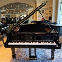 Alt text: Steinway & Sons grand piano showcasing polished ebony finish and high-quality keys in a chic showroom setting.