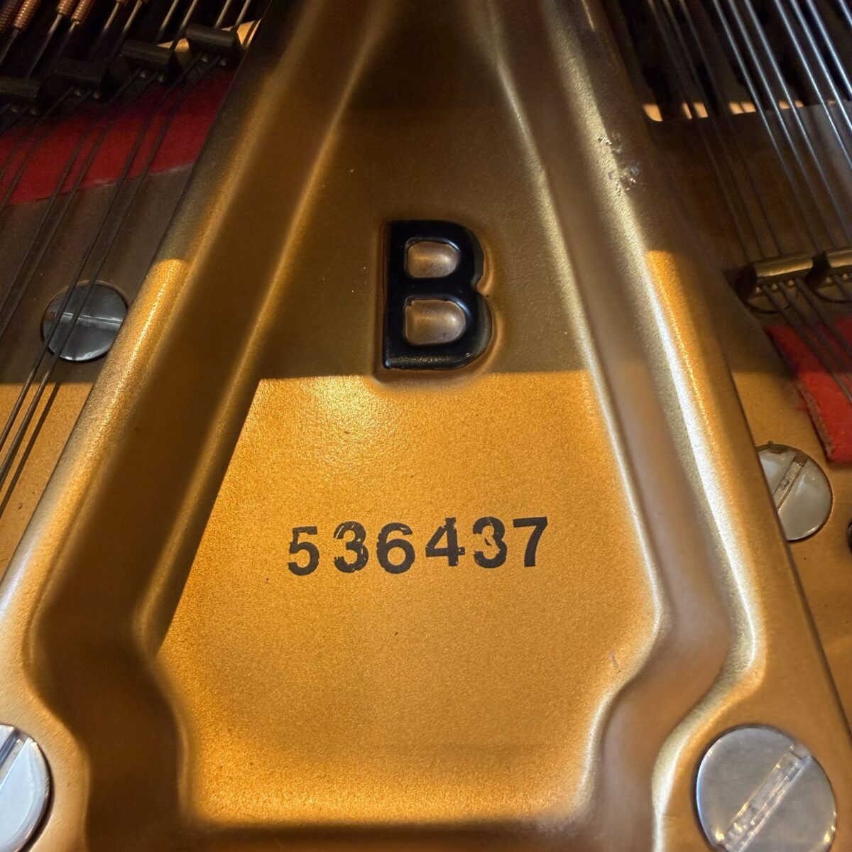 Close-up of piano's cast iron plate, showcasing the model B and serial number 536437 for Classic Pianos inventory.