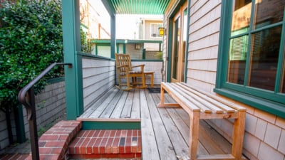 Charming porch seating at Classic Pianos' Portland location; visit us for grand and upright piano deals.