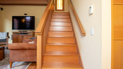 Wooden staircase in a cozy showroom setting at Classic Pianos Portland, showcasing warm interior design elements.